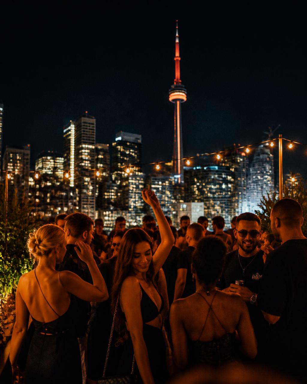 Large-scale branded event with crowd and city skyline at night